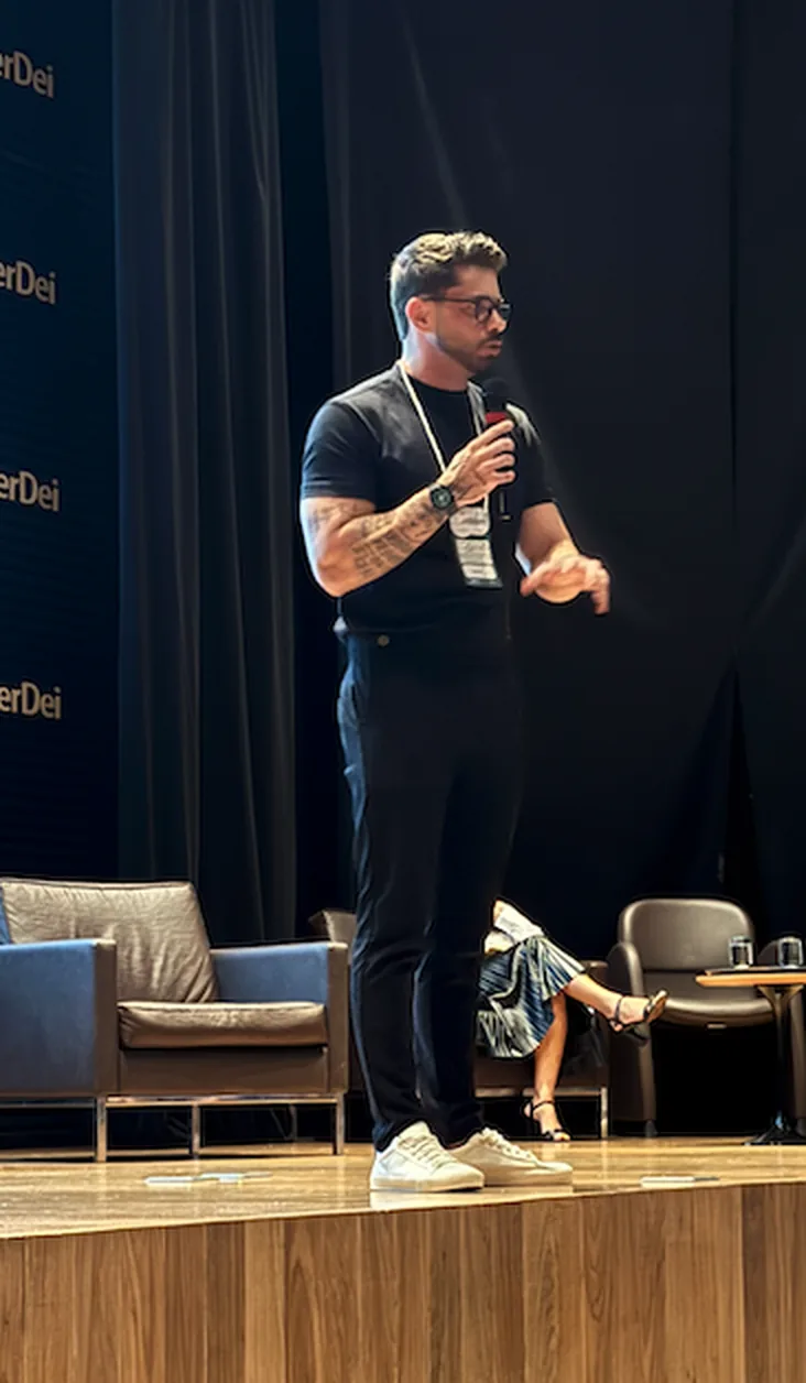 Prof. Vinicius falando ao microfone em um evento
